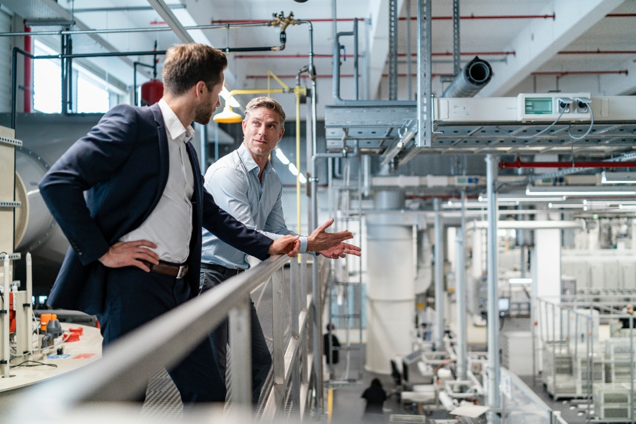 Two businessmen talking in a modern factory