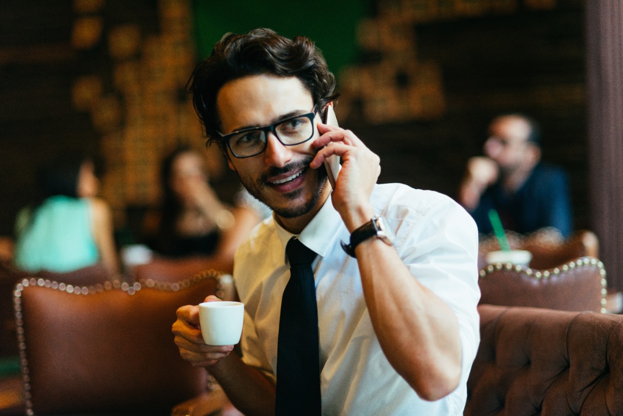 smiling businessman afterwork enoying his coffee in a bar