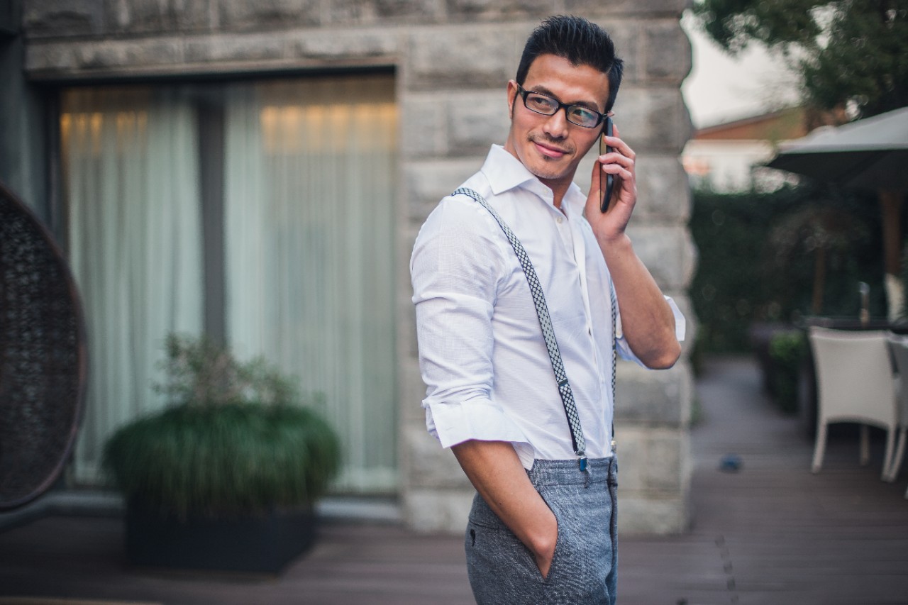 Businessman using phone by the swimming pool