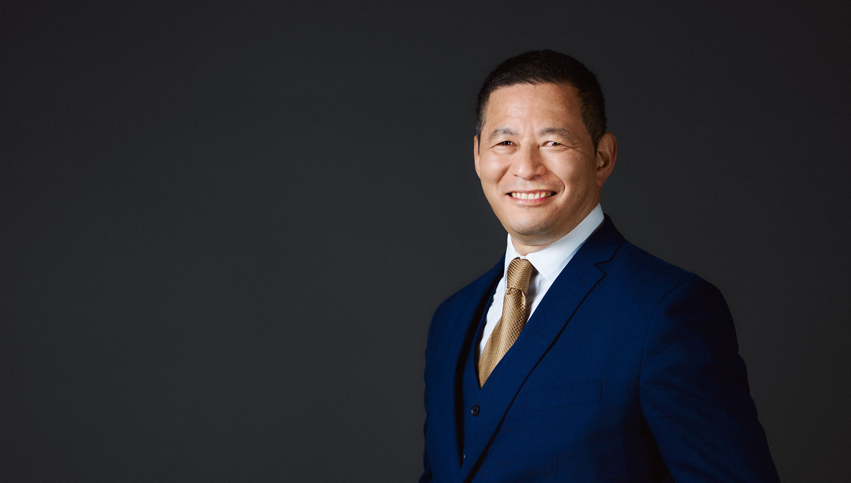 A man dressed in blue suit, smiling